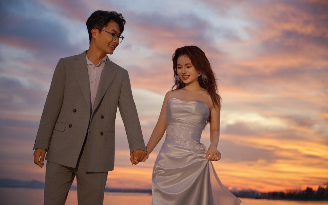 夕阳下的浪漫剪影，婚纱与晚霞融合。