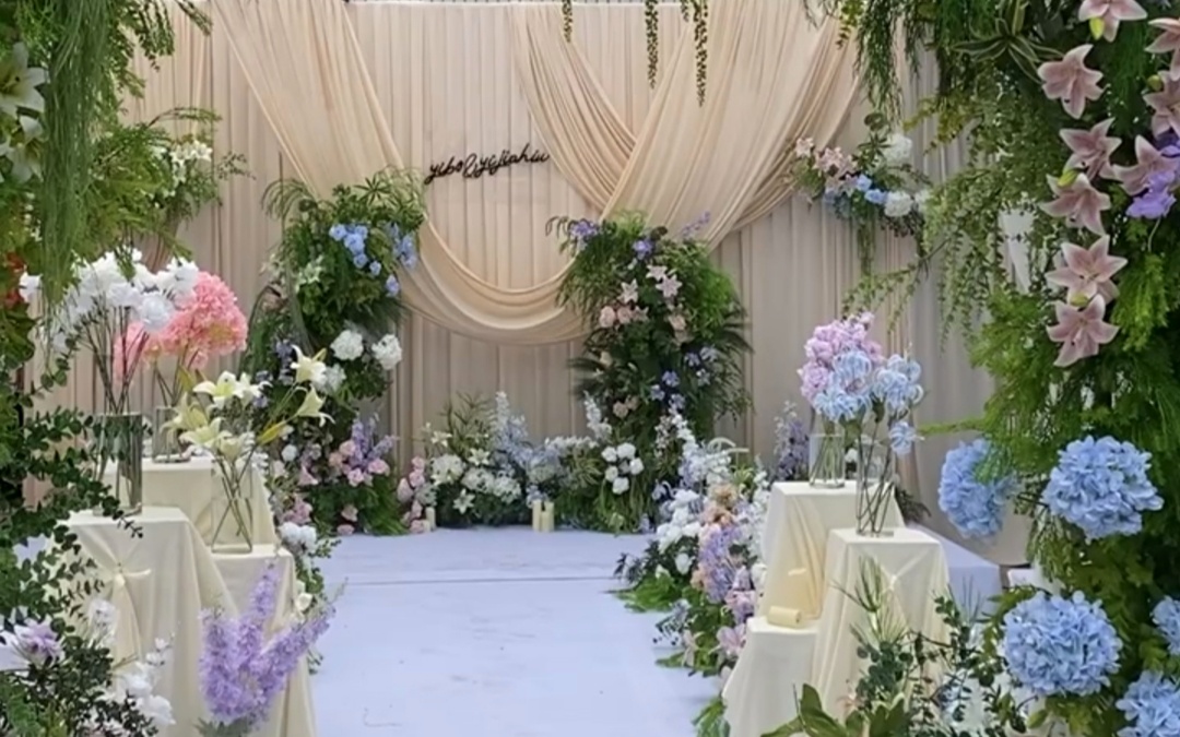 白绿花柱映衬花排，布幔轻扬营造雅致婚礼