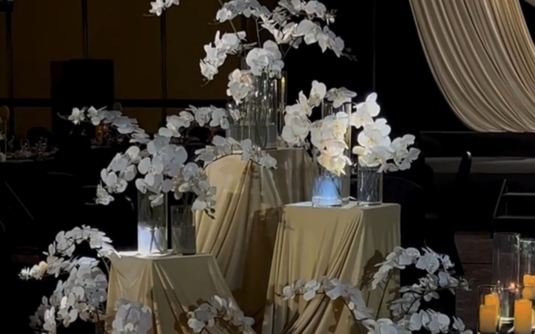 奶黄色布幔轻垂，线条流动，缀以素雅白花