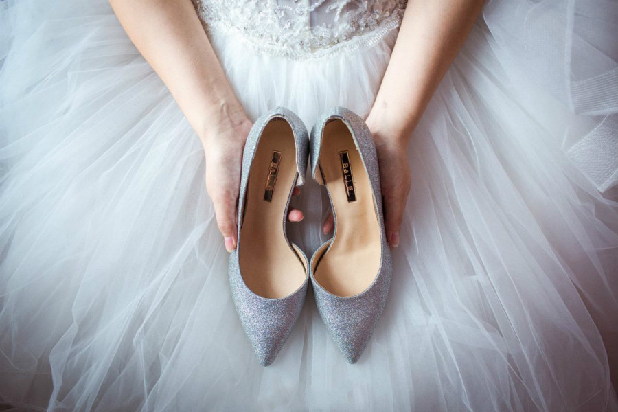 新娘穿婚纱捧着婚鞋